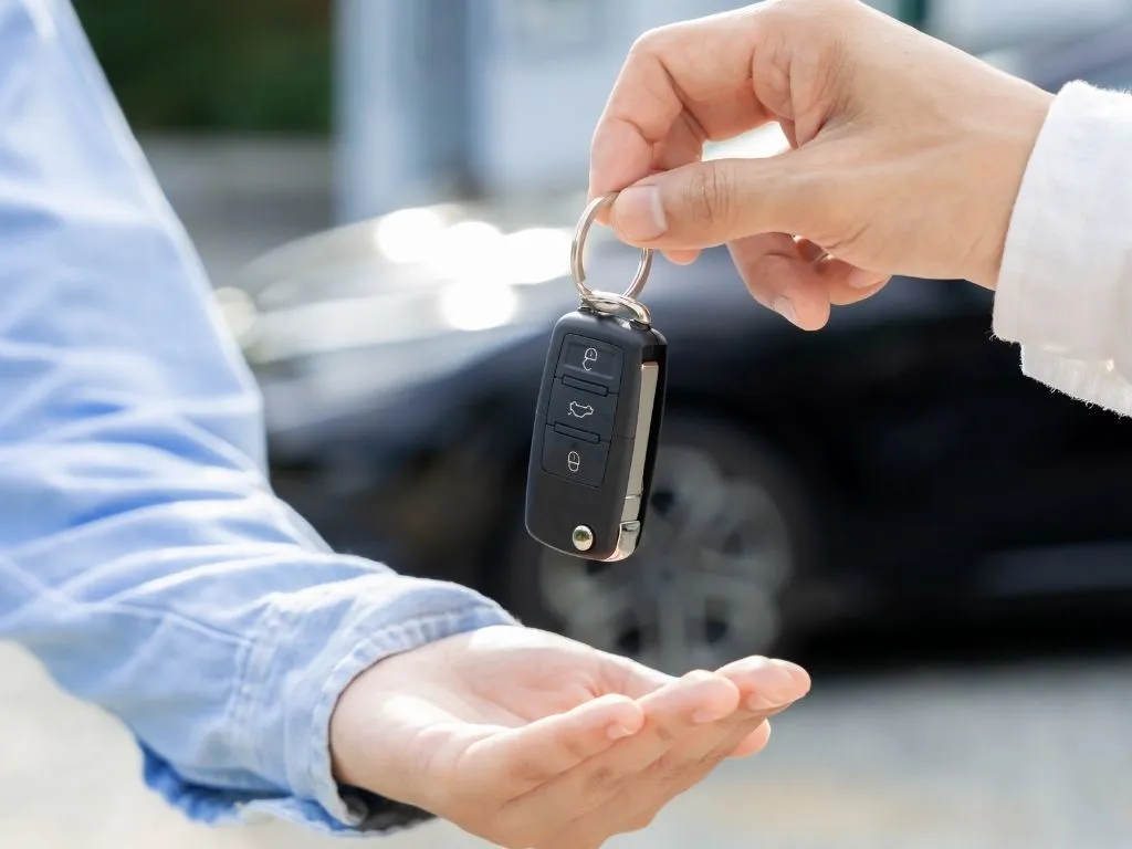 ซื้อรถ ภาพถ่ายมือที่ยื่นกุญแจรถให้มืออีกคนนึง